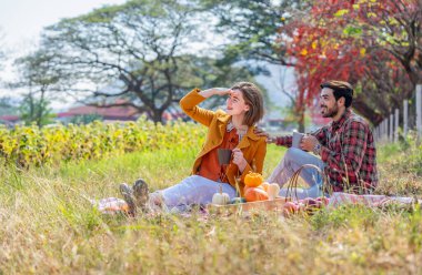 Kafkas ailesi sonbahar parkında piknik yapıyor. Genç romantik çift, sonbahar hasadını birlikte harika bir çayırda kutluyor.
