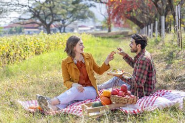 Kafkas ailesi sonbahar parkında piknik yapıyor. Genç romantik çift, sonbahar hasadını birlikte harika bir çayırda kutluyor.