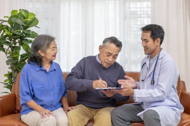 Asyalı üst düzey hasta bir belge imzalıyor, sağlık hizmetleri özel olarak yaşlı çiftten bakım evinden önce bilgilendirme izni istiyor.