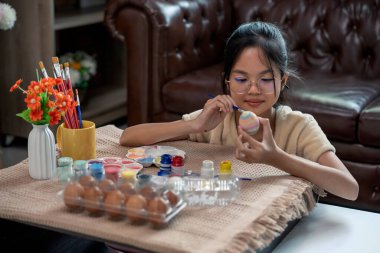 Paskalya kutlaması için yumurta boyayan bir kız. Geleneksel mevsim.