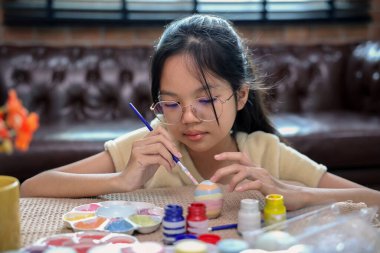 Paskalya kutlaması için yumurta boyayan bir kız. Geleneksel mevsim.