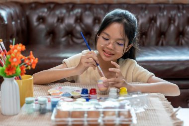 Paskalya kutlaması için yumurta boyayan bir kız. Geleneksel mevsim.