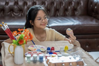 Paskalya kutlaması için yumurta boyayan bir kız. Geleneksel mevsim.