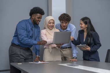 Çok ırklı iş arkadaşları konferans odasında görüştüler. İş adamı laptopla konuşuyor.