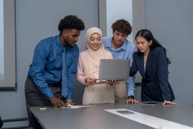 Çok ırklı iş arkadaşları konferans odasında görüştüler. İş adamı laptopla konuşuyor.