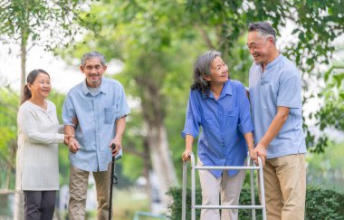 Bahçede yürüyen AIDS egzersizi yapan bir grup yaşlı insan, doğa, yaşlılık toplumu ve sağlık hizmetleri kavramında yürüyen mutlu yaşlılar.