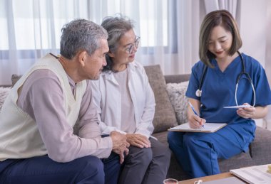 Asyalı yaşlı çift, evde civa ölçen ve onlara tavsiye veren, yaşlı sağlık hizmetleri, ev bakımı gibi konulara odaklan.