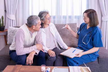 Yaşlı çift, evde civa ölçen ve tavsiyelerde bulunan ziyaretçi bir hemşireye konsantre olur. Yaşlılar için sağlık hizmeti kavramı, ev bakımı.