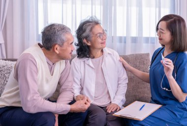 Yaşlı çift, evde civa ölçen ve tavsiyelerde bulunan ziyaretçi bir hemşireye konsantre olur. Yaşlılar için sağlık hizmeti kavramı, ev bakımı.
