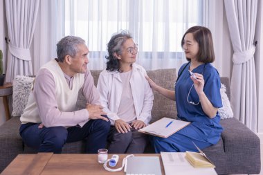 Yaşlı çift, evde civa ölçen ve tavsiyelerde bulunan ziyaretçi bir hemşireye konsantre olur. Yaşlılar için sağlık hizmeti kavramı, ev bakımı.