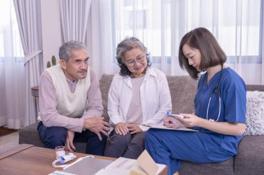 Asyalı yaşlı çift, evde civa ölçen ve onlara tavsiye veren, yaşlı sağlık hizmetleri, ev bakımı gibi konulara odaklan.