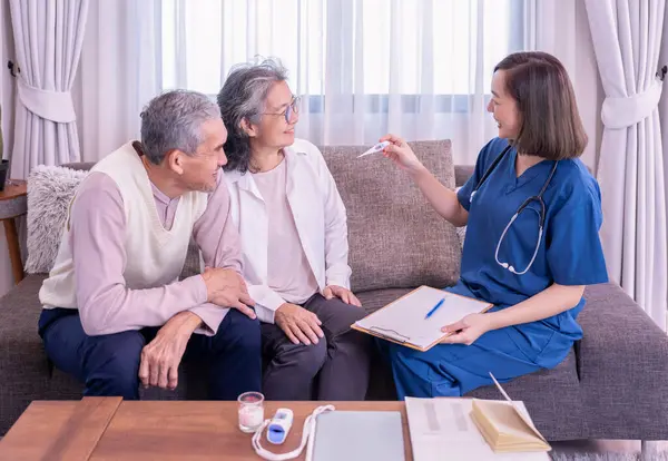 Yaşlı çift, evde civa ölçen ve tavsiyelerde bulunan ziyaretçi bir hemşireye konsantre olur. Yaşlılar için sağlık hizmeti kavramı, ev bakımı.