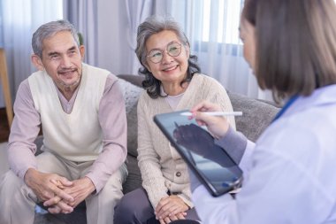 Genç bayan profesyonel doktor odada tablet bilgisayar kullanan yaşlı çiftlere danışmanlık yapıyor, yaşlı çiftlere özen gösteriyorlar.