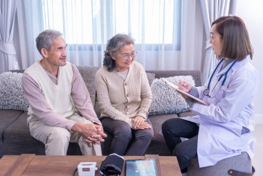 Kıdemli çift üniformalı doktorla konuşuyor. Evrak işleri, yaşlı sağlık hizmetleri, ev bakımı, sağlık sigortası hakkında danışmanlık yapıyor, inceleme yapıyor, bilgi topluyor.