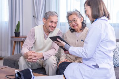 Genç bayan profesyonel doktor odada tablet bilgisayar kullanan yaşlı çiftlere danışmanlık yapıyor, yaşlı çiftlere özen gösteriyorlar.