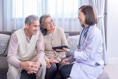 Genç bayan profesyonel doktor odada tablet bilgisayar kullanan Asyalı yaşlı çifte danışmanlık yapıyor.