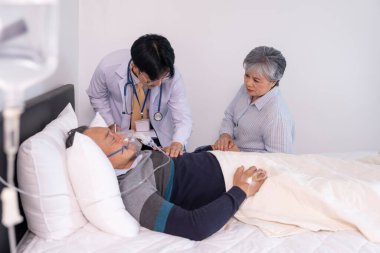 Hüzünlü yaşlı bir kadının ölüm döşeğinde, serum ve oksijenle el ele tutuşması, bir doktorun fiziksel muayene, konsept palyatif bakım, yaşam bakımı,