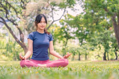 Parkta yoga yapan genç Asyalı kadın, insanların yaşam tarzı, egzersiz.