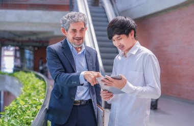 Kampüs binasında tavsiye veren kıdemli profesör, elinde tablet bilgisayar danışmanı olan genç bir adam araştırma çalışması, okula dönüş konsepti ve eğitim hakkında bilgi veriyor.  