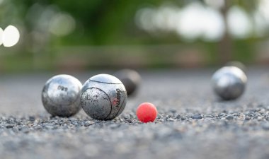 Petanque topları grubu ve oyun sahasında pembe küçük tahta kriko (seçici odaklanma), spor, oyun, yarışma