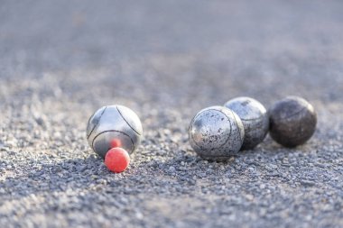 Petanque topları grubu ve oyun sahasında pembe küçük tahta kriko (seçici odaklanma), spor, oyun, yarışma
