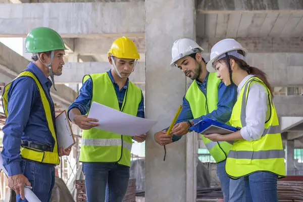 Binanın yapısını inceleyen mühendis ekibi yeni inşaat halinde. Tasarıya, inşaat mühendisliğine, iç teftişe, kalite kontrolüne göre şeritle beton kolonu ölçüyorlar. 
