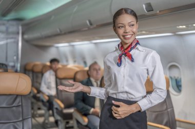 Üniformalı hostes portresi uçaktaki yolculara, iş havayollarına, ticari uçuşlara katılıyor.