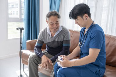 Erkek hemşire, ev ziyareti sırasında nabız oksimetrelerini ölçüyor.