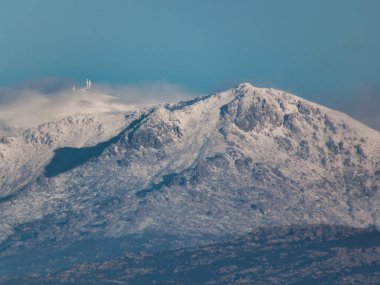 Madrid yakınlarındaki Sierra de Guadarrama dağlarının dağ manzaralı zirveleri bulutlu bir gökyüzüne karşı.