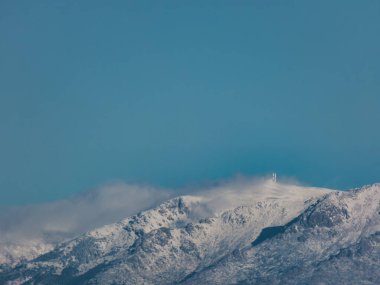 Madrid yakınlarındaki Sierra de Guadarrama dağlarının dağ manzaralı zirveleri bulutlu bir gökyüzüne karşı.