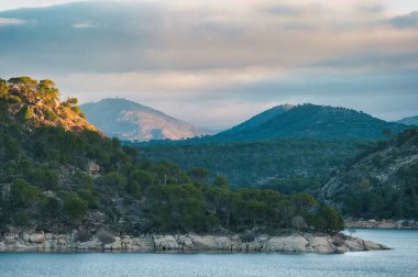 Madrid yakınlarındaki Pelayos de la Presa köyünde Alberche nehri ile birlikte dağ manzarası.