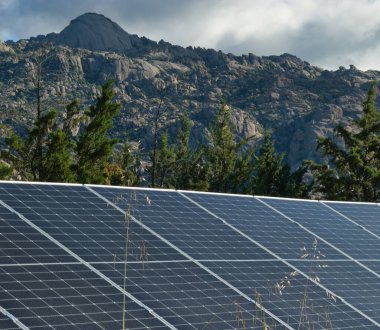 Dağ zirvelerinin arka planına karşı fotovoltaik güneş panelleri
