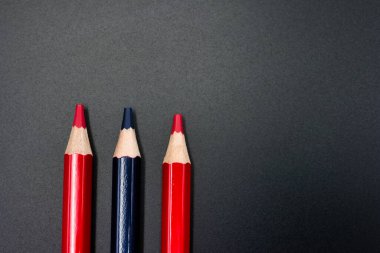 ...Düz arkaplanda kırmızı ve mavi renkli ahşap kalemler.