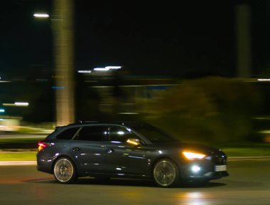 Bulanık bir arka planı olan gece yolculuk yapan bir yolcu aracı.