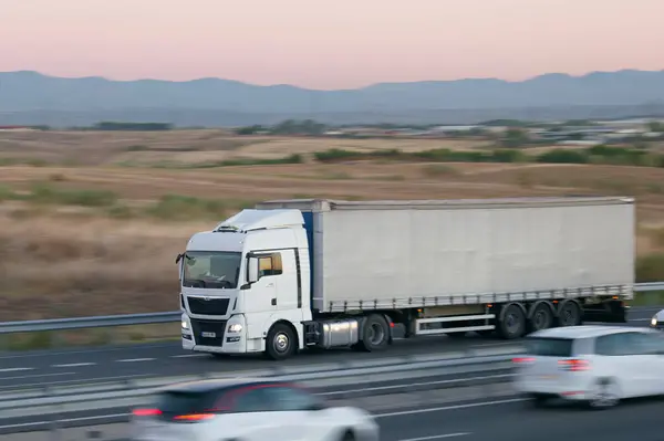 Kamyon sabah bulanık arkaplanla hareket ediyor.
