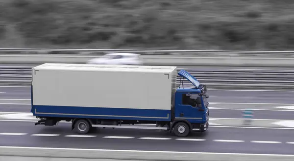 Otobanda hareket halindeki kamyonun arka planı bulanık.