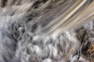 Güzel bir arka plan parıltısı ve ışık gibi bir derede akan su.