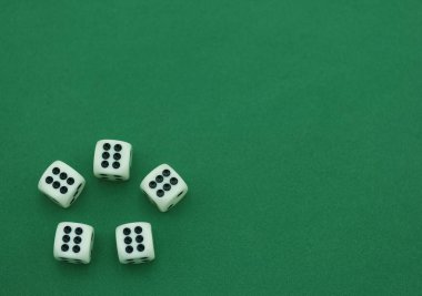 Yeşil bir yüzeyde beş beyaz zar var, her birinde farklı numaralar var. Sıradan bir ortam. Arkadaşlarla ya da ailelerle oyun gecesi yapmayı öneriyor. Heyecan ve eğlenceyi teşvik ediyor..