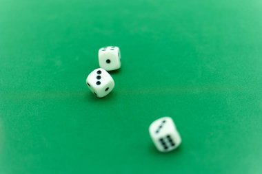 Üç beyaz zar canlı yeşil bir keçeli oyun masasına dağılmış, çeşitli sayılar gösteriyor. Arkadaşlar toplanır, oyun ve kahkahalarla dolu keyifli bir akşamın tadını çıkarırlar..