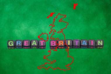 Büyük Britanya kelimelerini oluşturmak için düzenlenmiş renkli bloklar, Britanya Adaları 'nın ana hatlarını ön plana çıkaran parlak yeşil bir zemin üzerine kurulmuştur..