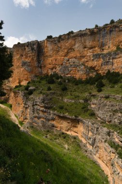 Nefes kesici bir kanyon, yeşilliklerle çevrili canlı turuncu renkleri olan yüksek uçurumları ortaya çıkarıyor. Açık gökyüzü huzurlu atmosfere katkıda bulunur. Doğa bu gözlerden uzak yerde gelişir..