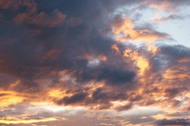 Güneş batarken canlı renkler gökyüzünü dolduruyor, akşam saatlerinde turuncu, mor ve mavi tonlarıyla kabarık bulutları aydınlatıyor, dingin bir atmosfer yaratıyor..