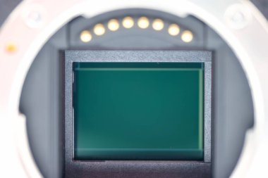 Yakın plan, merkezinde ışık yakalamak için tasarlanmış bir sensör bulunan bir kameranın içini gösteriyor..