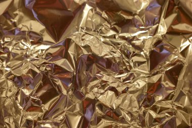 Yüzeyde ışığı yansıtan, gölgeler ve röflelerin dinamik etkileşimini yaratan kırışık altın folyo var. Karmaşık dokular yüzeye derinlik ve ilgi ekler..