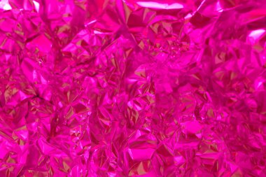 Parlak pembe folyo buruşmuş ve yansıtıcıdır. Işık yüzeyiyle etkileşime girdikçe dinamik desenler oluşturur. Canlı renk, dokulu görüntüyü güzelleştirir, onu görsel olarak çarpıcı kılar..