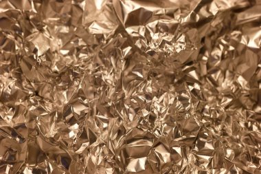 Metalik folyo, değişik altın ve kahverengi tonlarıyla karmaşık bir doku yaratır. Buruşuk yüzey, ışığı güzel bir şekilde yakalayan büyüleyici desenler oluşturuyor..