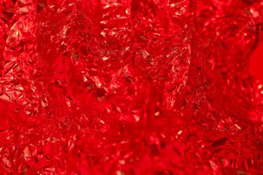 Parlak kırmızı folyo karmaşık bir şekilde katmanlanmış. Işığı yakalayan parıldayan yansımalarla dinamik ve soyut bir zemin oluşturuyor. Enerji ve sıcaklık hissi uyandırıyor..