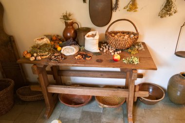 Kırsal bir masa tahıllar, fındıklar, meyveler ve kurutulmuş otlar da dahil olmak üzere mevsimlik çeşitli ürünleri sergiler. Sıcak ve davetkar ev ortamları geleneksel bir yaşam tarzını yansıtıyor..