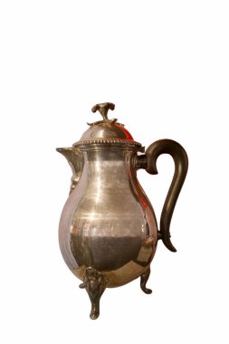 Zarif bir gümüş çaydanlık belirgin bir şekilde duruyor. Dekoratif bir sapı ve detaylı bir tasarımı var. Bu eser, her yemek düzenine uygun nitelikli metal ve estetik güzelliği yansıtıyor..