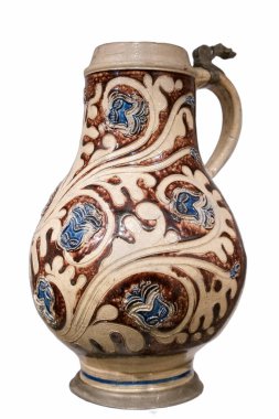Bu güzel seramik sürahi detaylı mavi çiçek desenleri ve dönen kahverengi tasarımları içeriyor. Geleneksel zanaatkarlığın göz kamaştırıcı bir örneği..